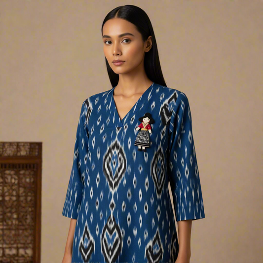 Model wears the Gudiya Ikat Kurta, a straight-cut indigo blue handloom piece with a detachable doll brooch.